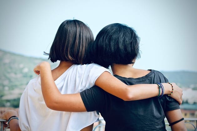 due amiche di spalle che si abbracciano