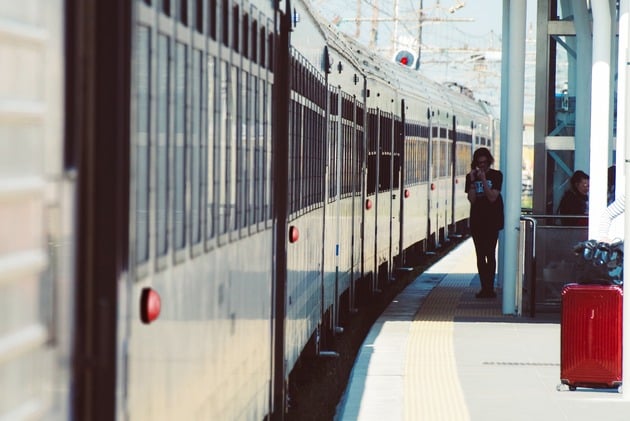 Tren detenido con una persona en la plataforma lista para partir